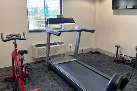 Red bicycle and trend mile in the gym facility room with carpet