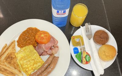 Ala catte breakfast with orange juice, water and vanilla and bran muffins with utensils