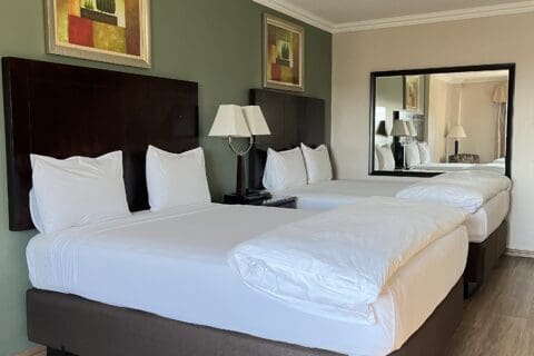 Hampshire hotel 2 Queen beds with white linen sheets and covers with 2 lights of pedestals