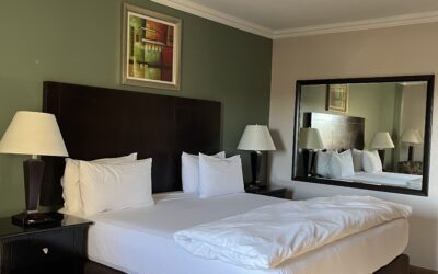 Hampshire hotel King bed with white linen sheets and cover with pedestals and lights