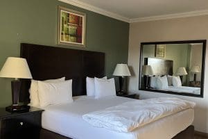 Hampshire hotel King bed with white linen sheets and cover with pedestals and lights